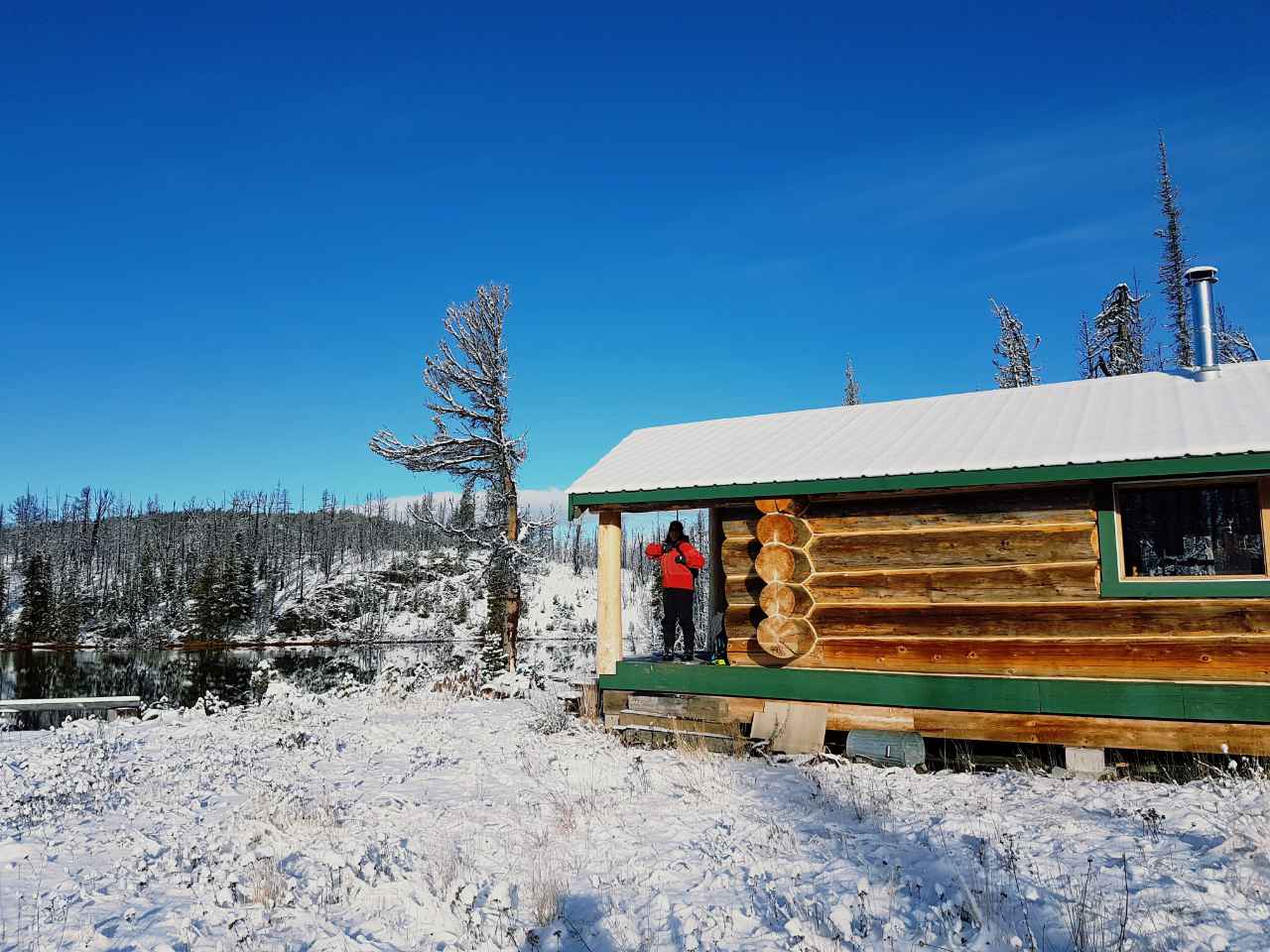 The overnight cabin run by Tweedsmuir Ski Club in snow covered meadow and next to fresh water lake